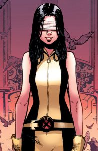 Description: A young woman with light skin, long black hair, and a bandage wrapped across her eyes, smiles. Her belt holds the X-Men team logo.