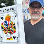 man holding the discard poster colored in a protest